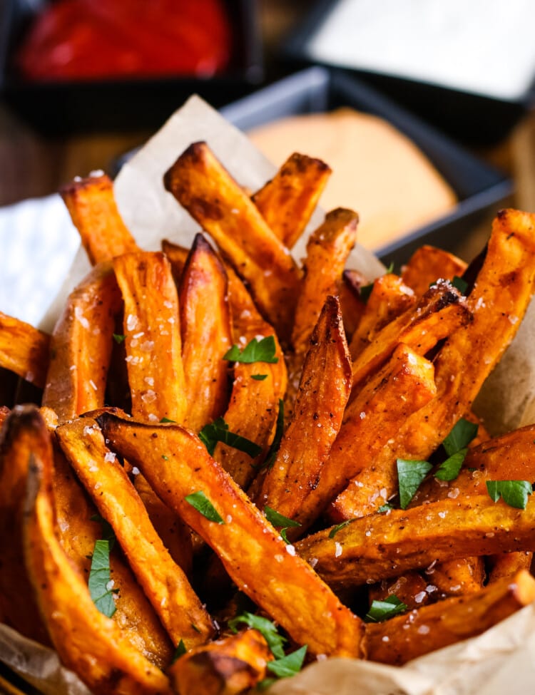 Air Fryer Sweet Potato Fries in a cup and garnished with parsley