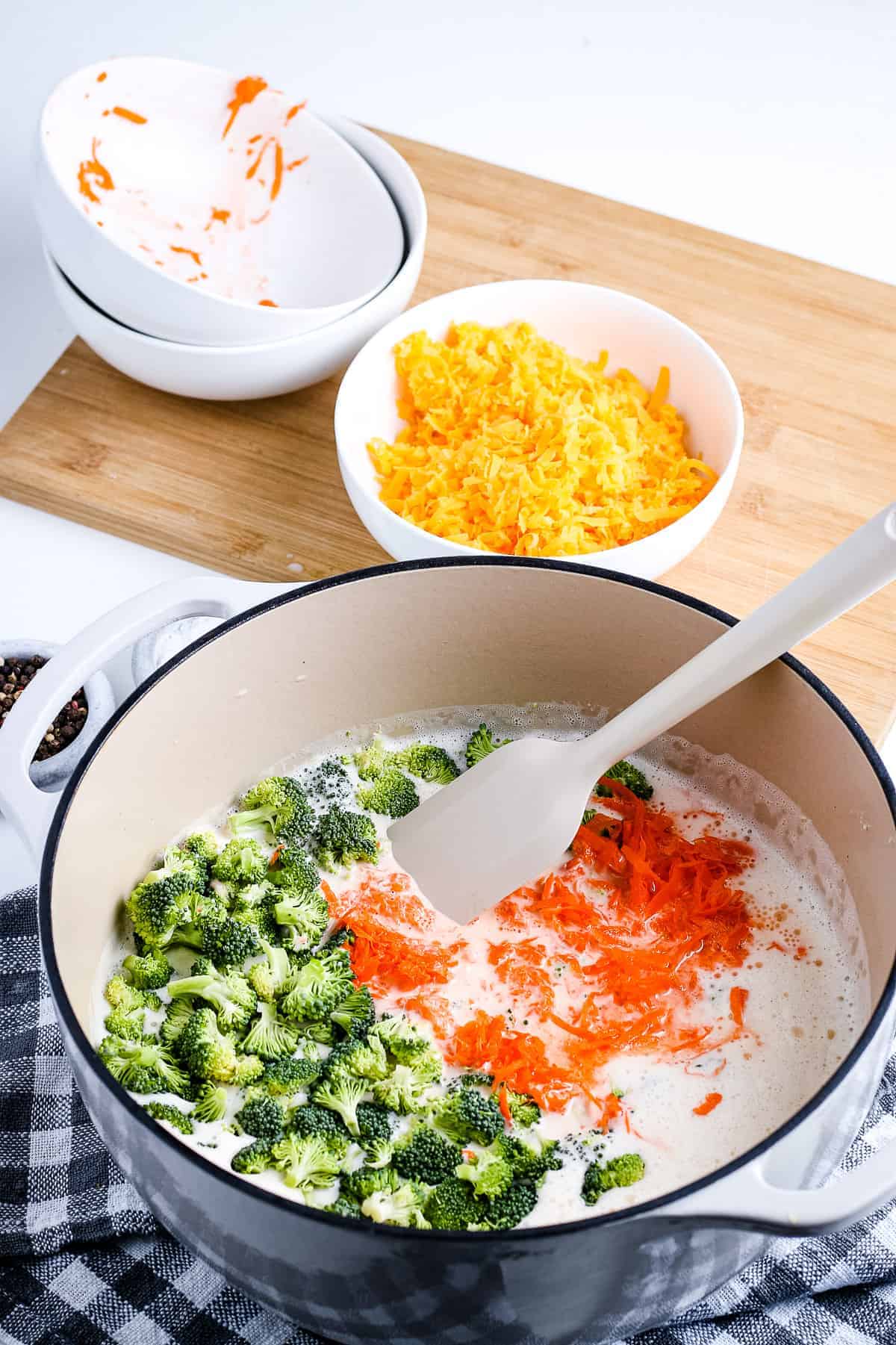 Chopped broccoli and carrots in dutch oven with soup base