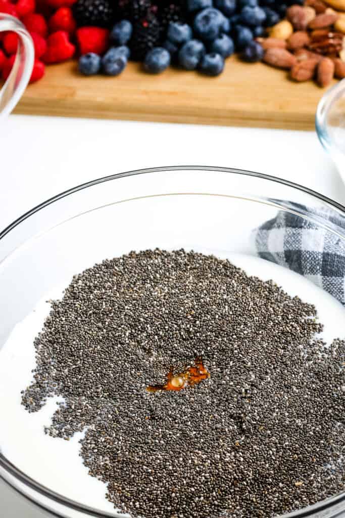 Glass bowl with ingredients to make chia pudding before mixing