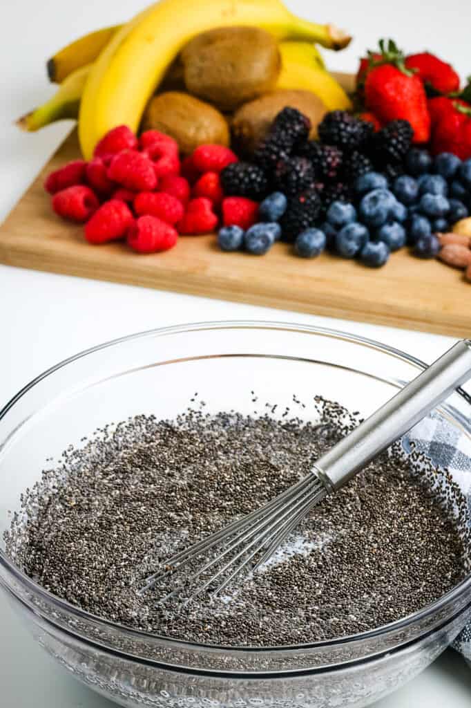 Glass bowl with ingredients to make chia pudding with whisk mixing