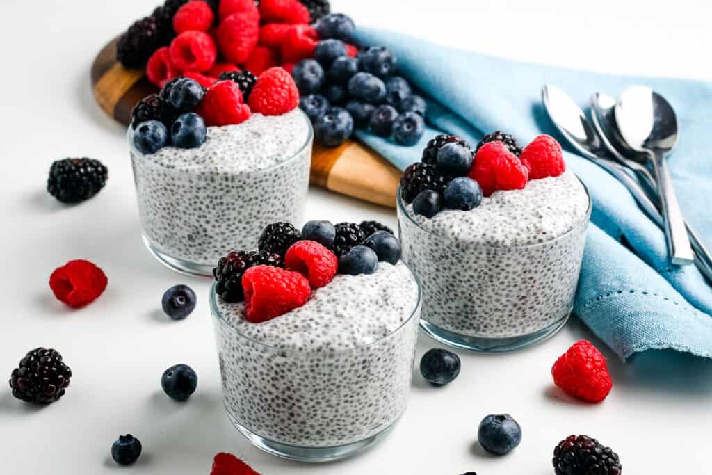 Three Glass bowls of Chia Pudding topped with berries