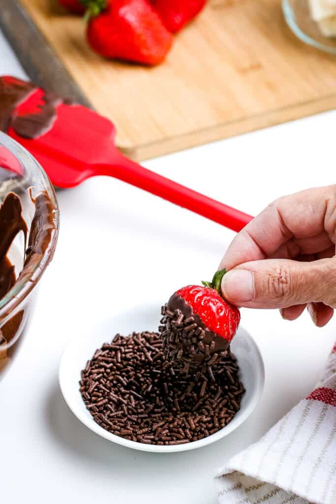 Chocolate Covered Strawberry being dipped in chocolate sprinkles