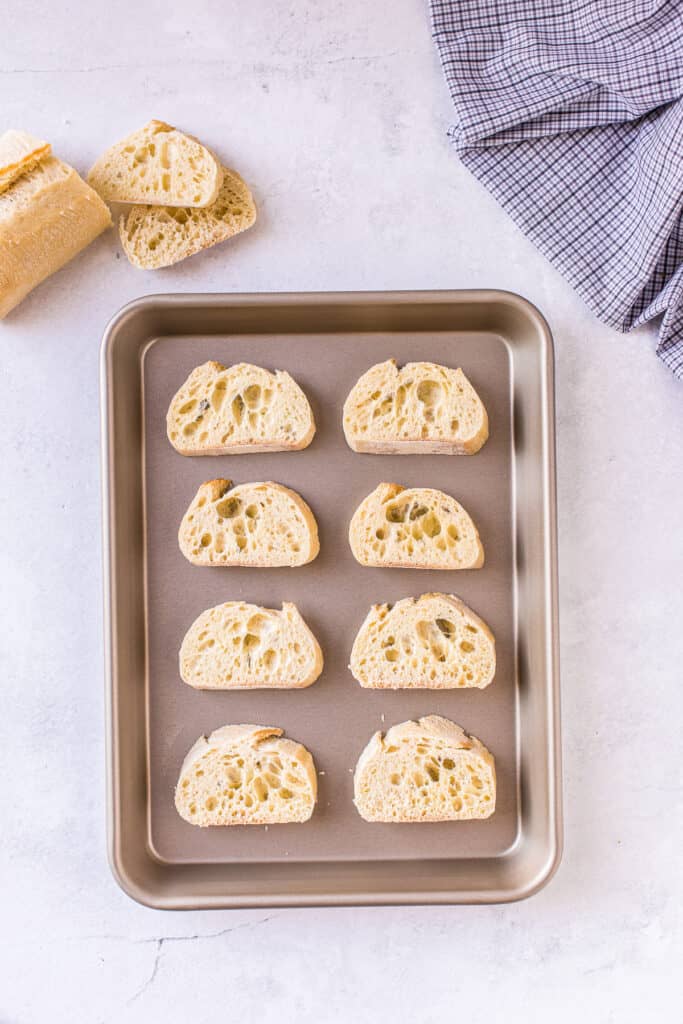 Baguette sliced on baking sheet