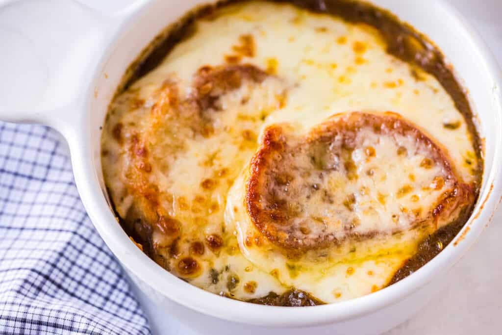 Close up overhead image of French Onion Soup in white bowl