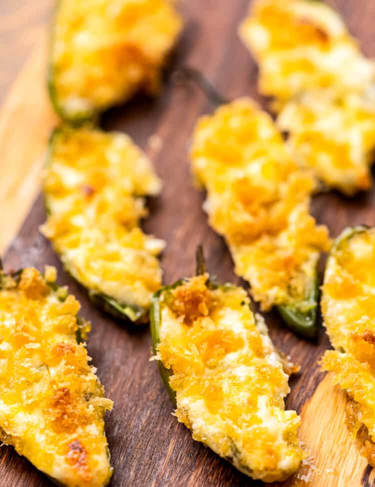 Wood cutting board with baked jalapeno poppers.