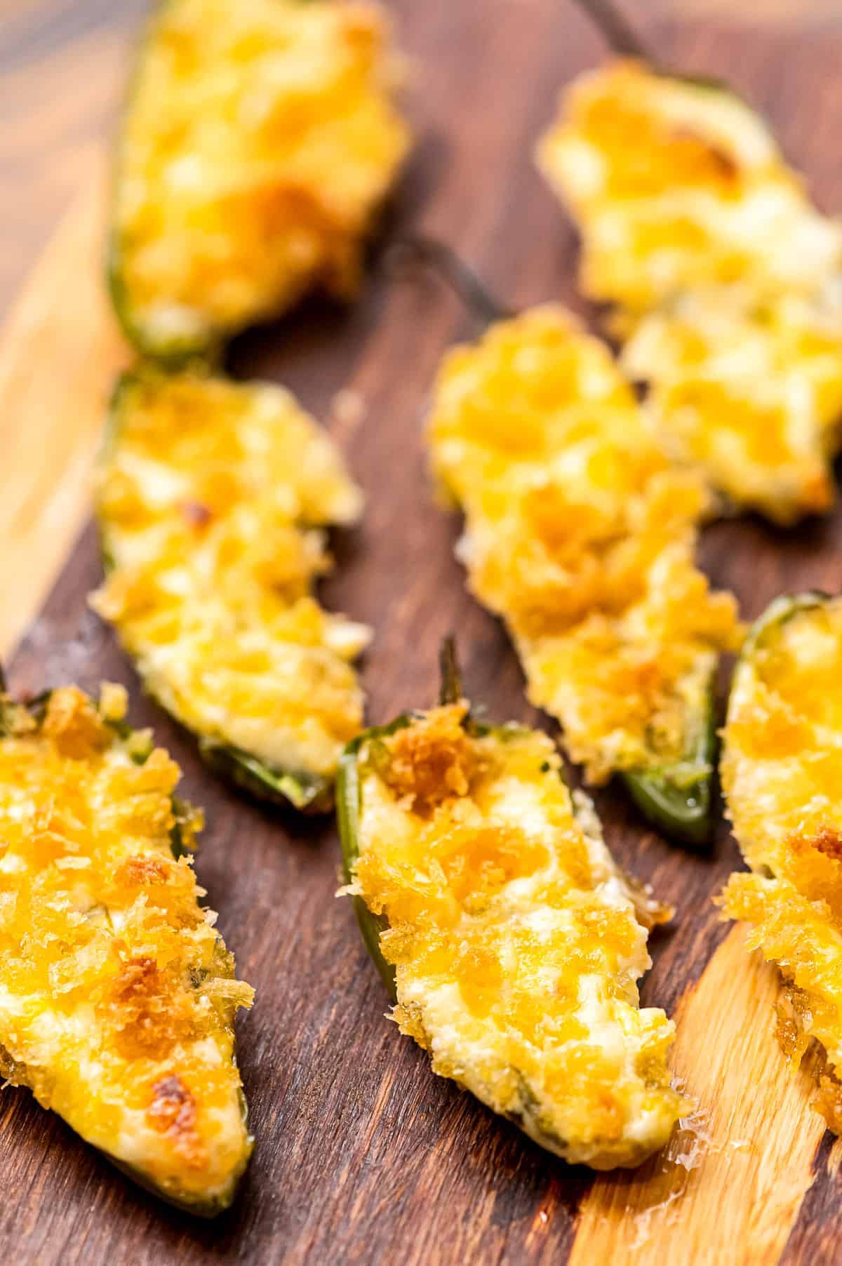 Wood cutting board with baked jalapeno poppers.