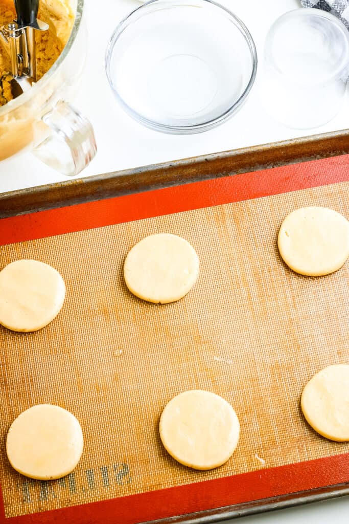 Silpat lined baking sheet with sugar cookies on it