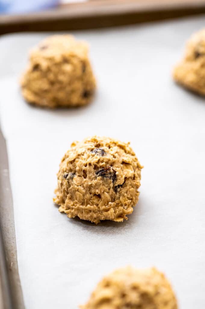 Raw oatmeal raisin cookies on baking sheet