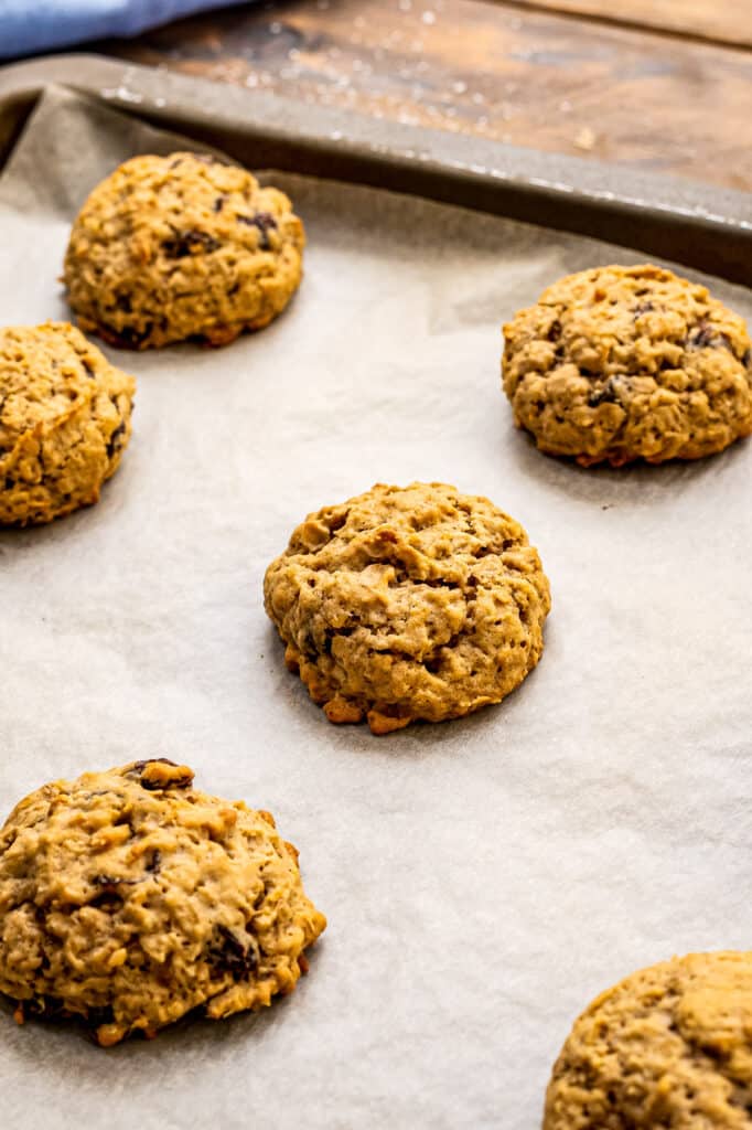 Baking sheet with baked oatmeal raisin cookies on it