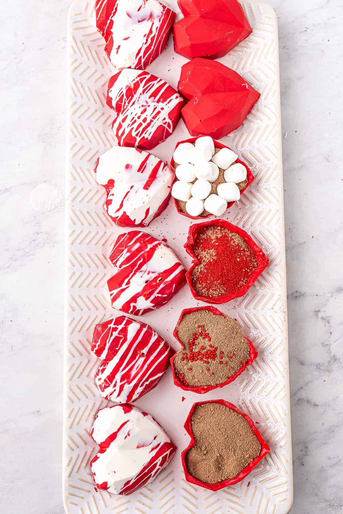 Heart Hot Chocolate Bombs halves with hot cocoa mix and mini marshmallows in them