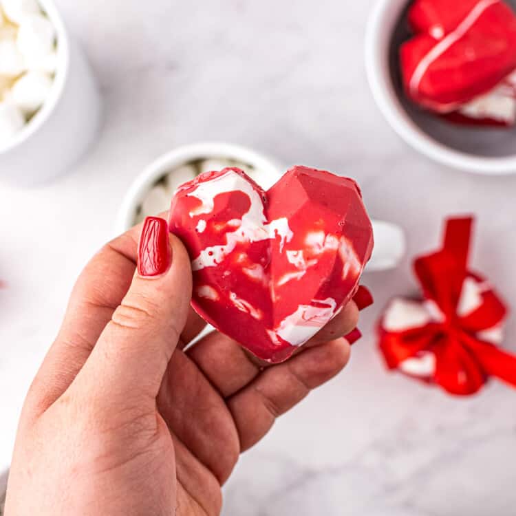 Hand holding heart hot cocoa bomb