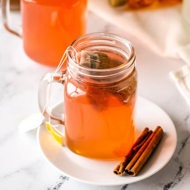 Starbucks Medicine Ball Tea in a mason jar on a white plate with cinnamon sticks