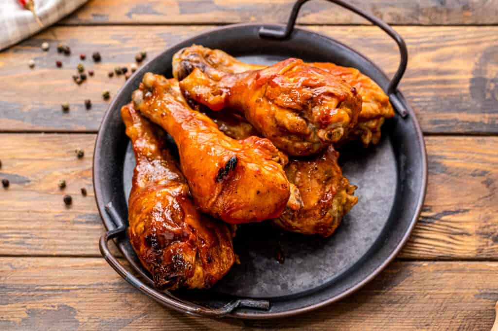 BBQ Chicken legs on black serving dish with handles