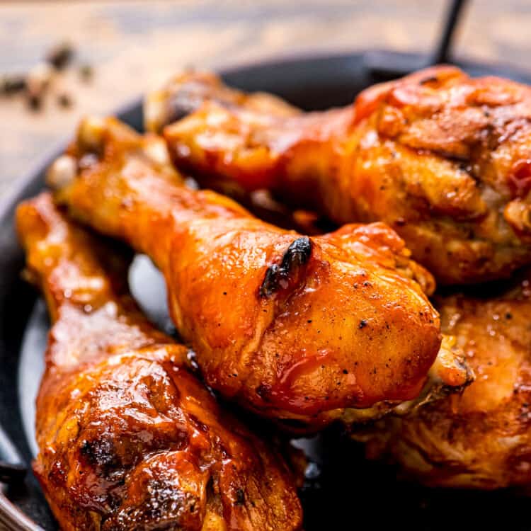 Black platter with handles with chicken drumsticks on it