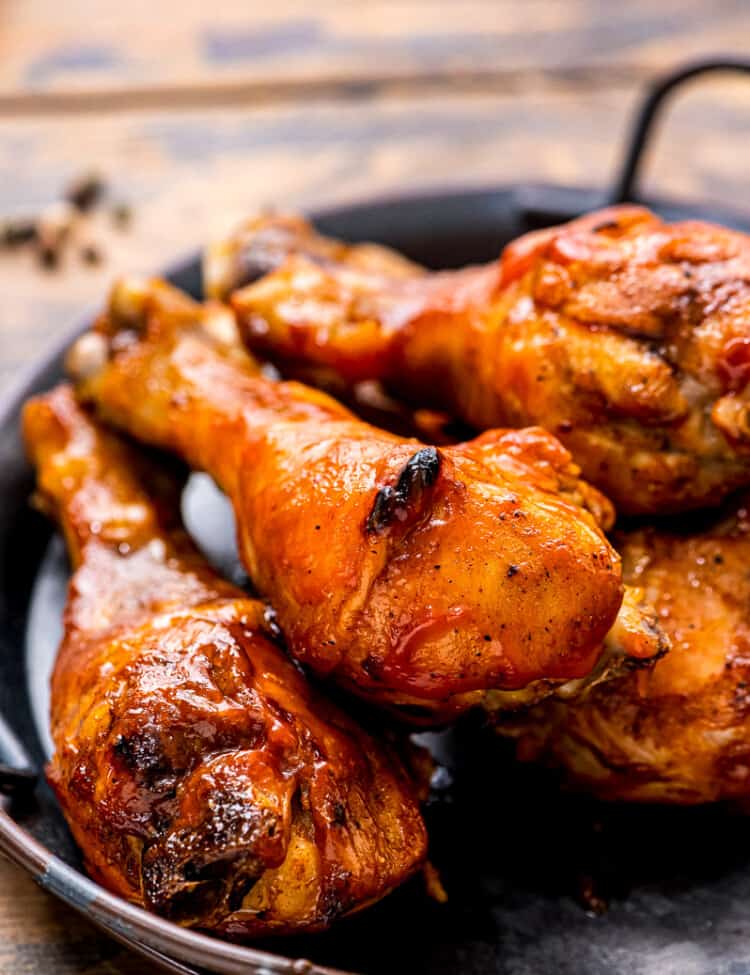 Black platter with handles with chicken drumsticks on it