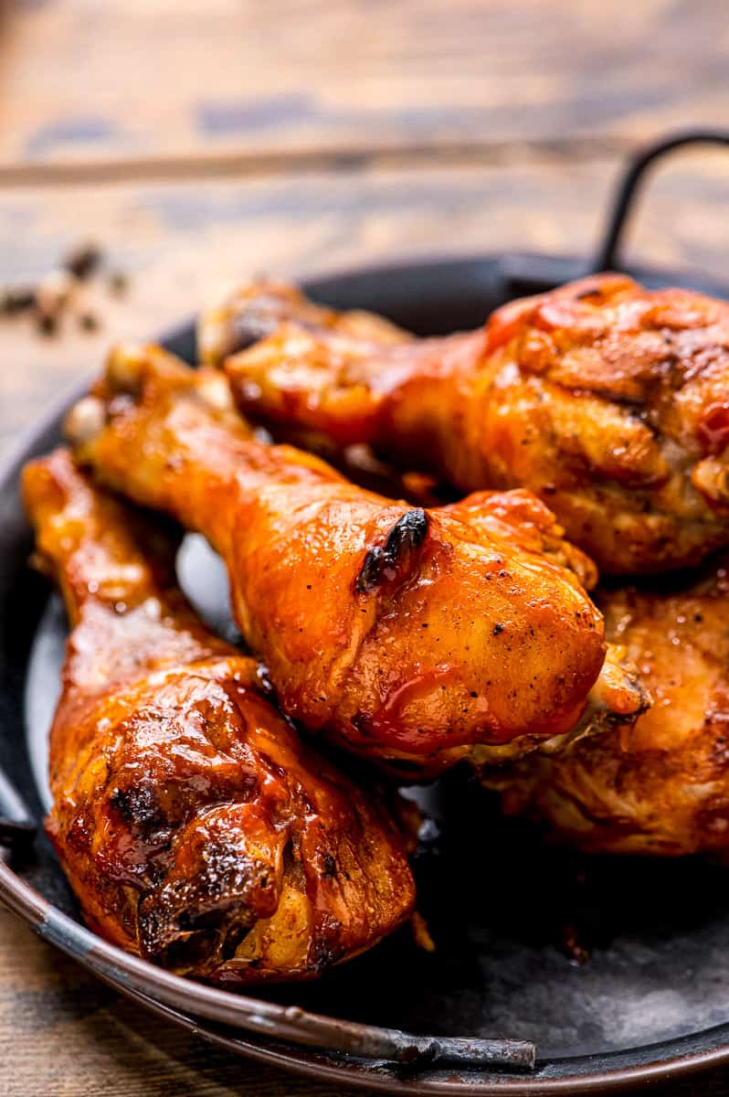 Black platter with handles with chicken drumsticks on it