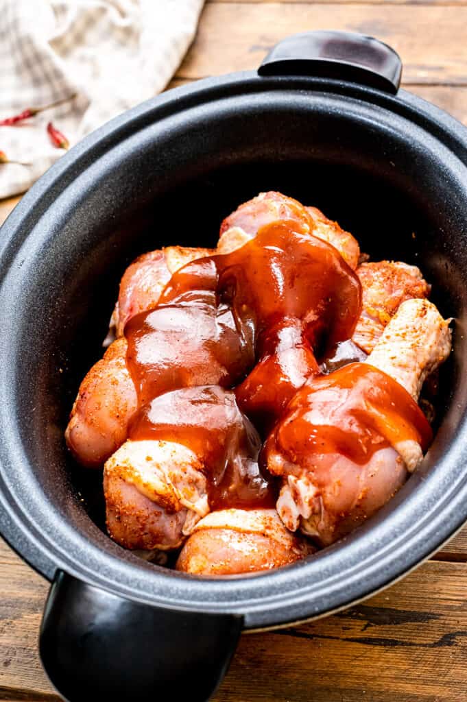 Chicken Legs in crock pot covered with bbq sauce