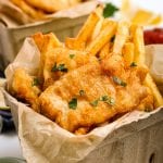 Beer Battered Fish and Chips in cardboard containers and garnished with parsley.