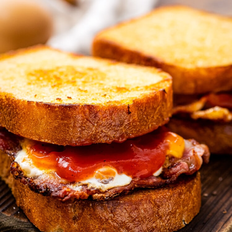 Fried Egg Sandwich sitting on a piece of wood cutting board.