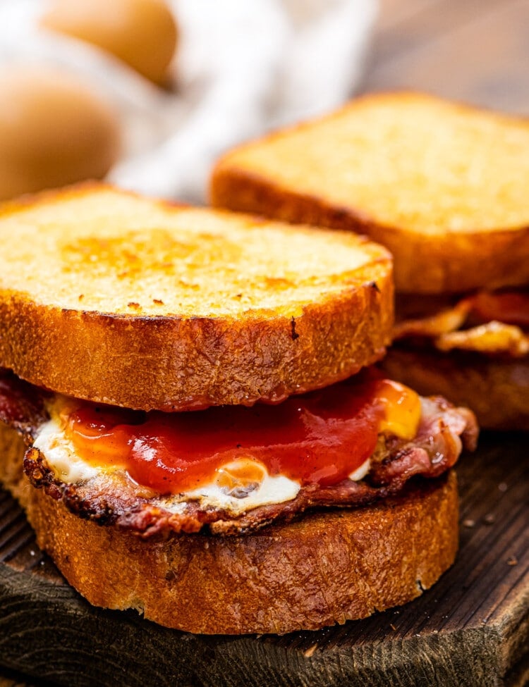 Fried Egg Sandwich sitting on a piece of wood cutting board.