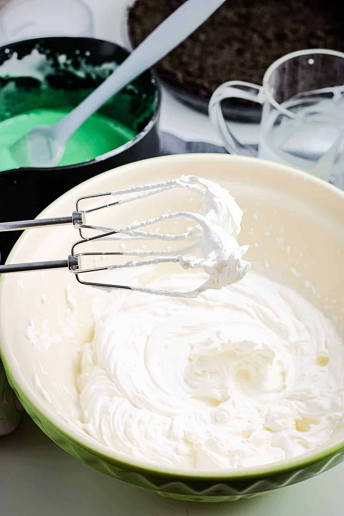 Bowl of whipped cream and hand mixer