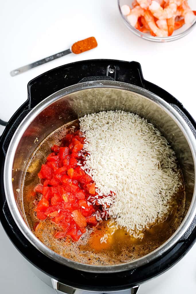 Diced tomatoes and rice added to pressure cooker