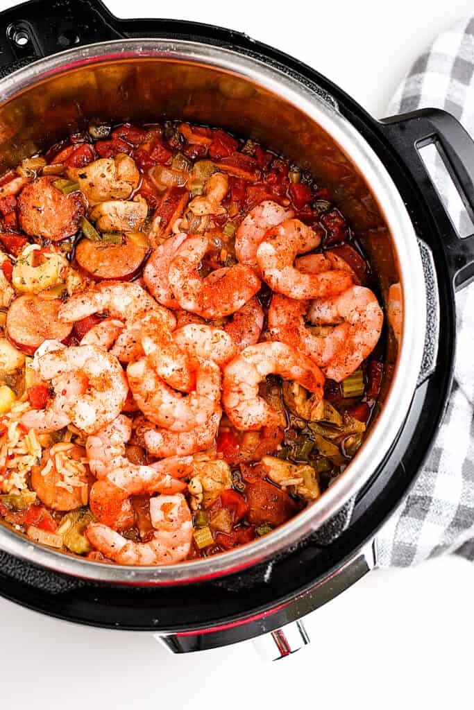 Add shrimp and seasonings to jambalaya in pressure cooker