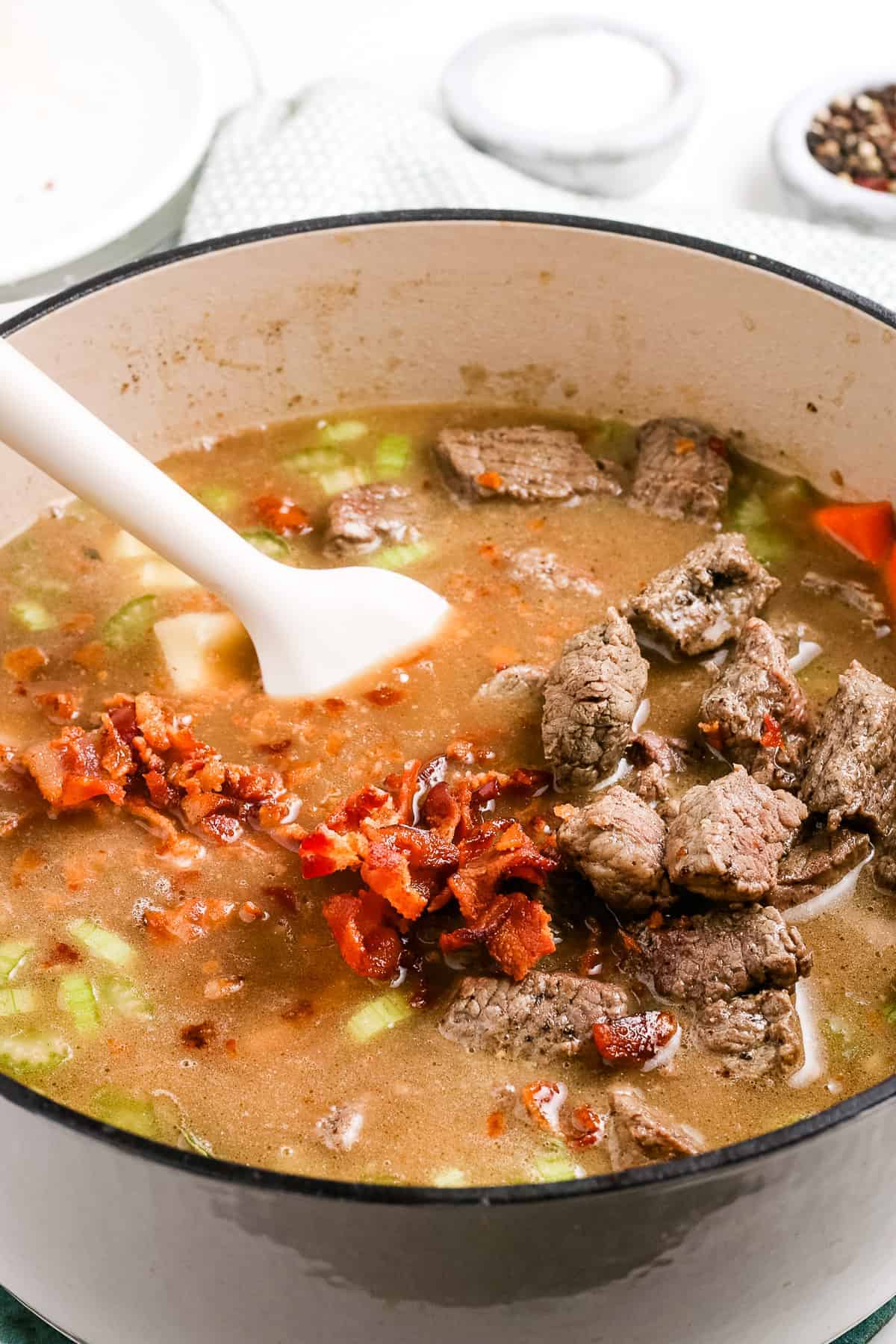 Stirring ingredients for Irish Beef Stew together in Dutch oven.