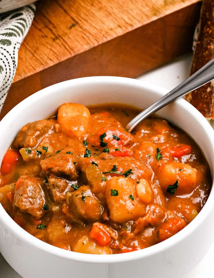 Overhead close up of a white bowl with Irish Beef Stew garnished with chopped parsley