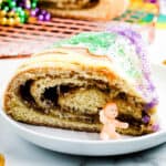 Close up of a slice of King Cake with plastic baby