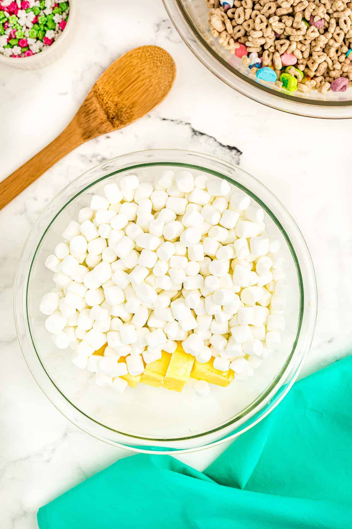 Overhead image of glass bowl with marshmallows and butter