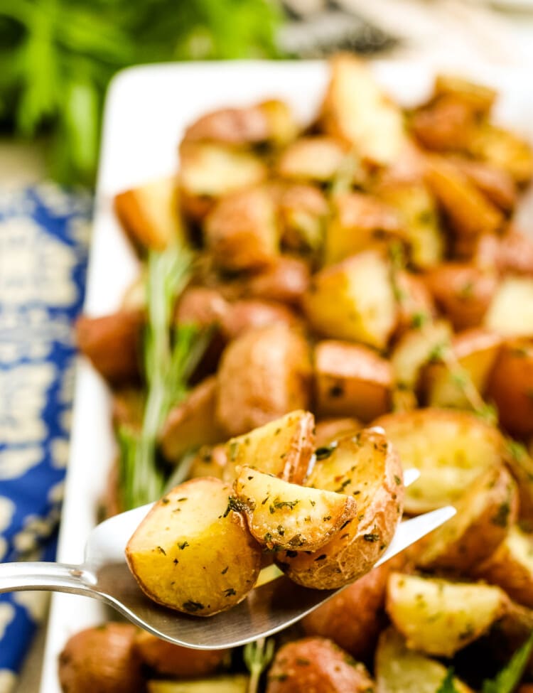 Oven Roasted Potatoes on a serving spoon with a platter of more potatoes in background