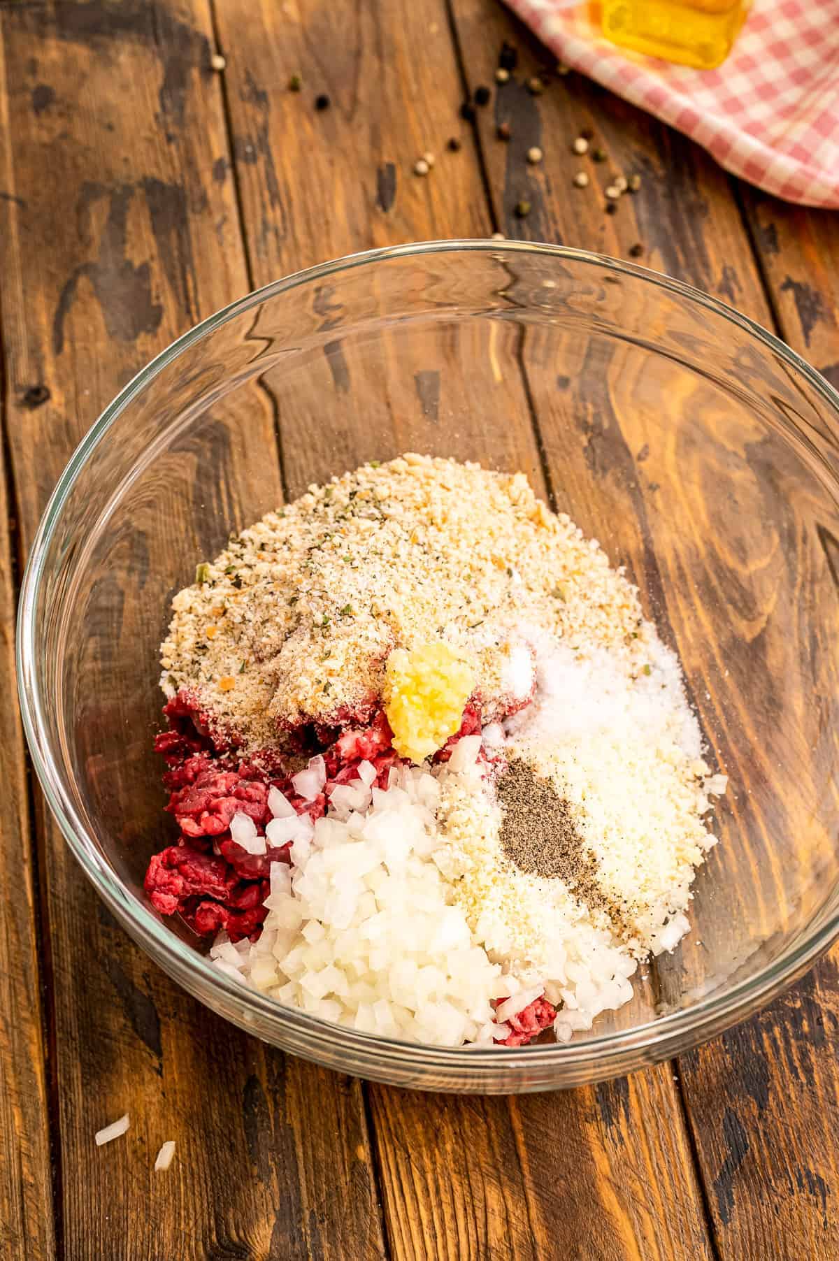 Glass bowl with ingredients to make homemade meatballs