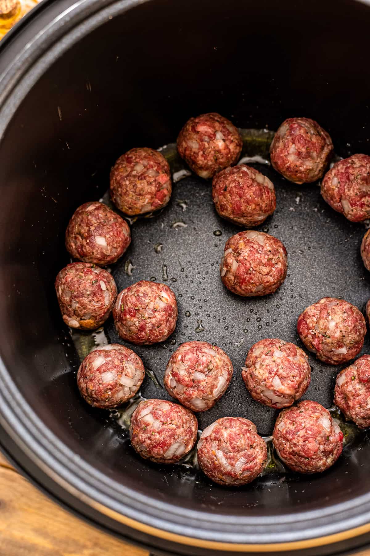 Instant Pot with raw meatballs being browned.