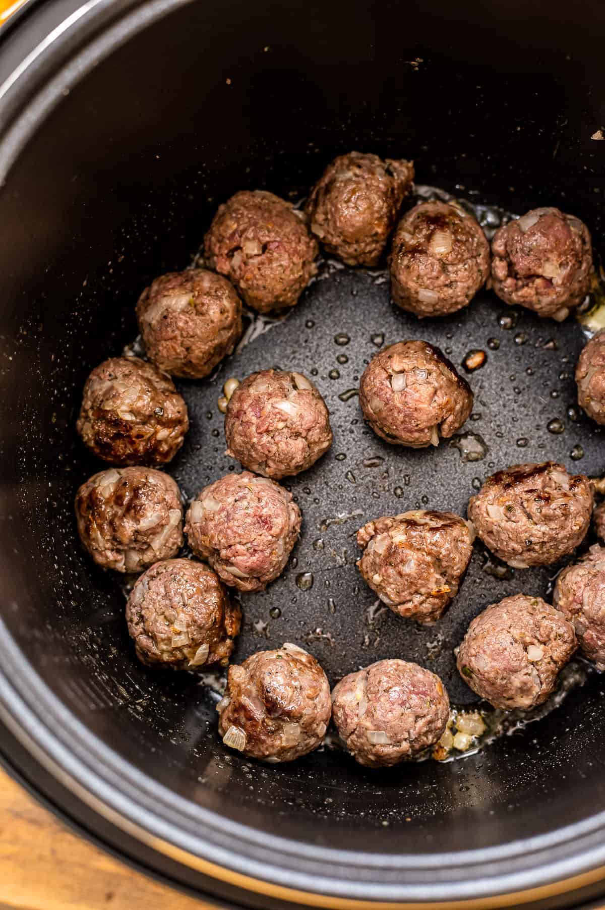 Instant Pot with browned meatballs in it.