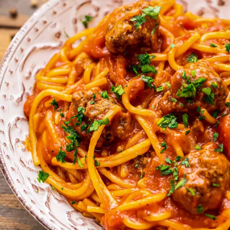 Bowl of spaghetti and meatballs topped with parsely