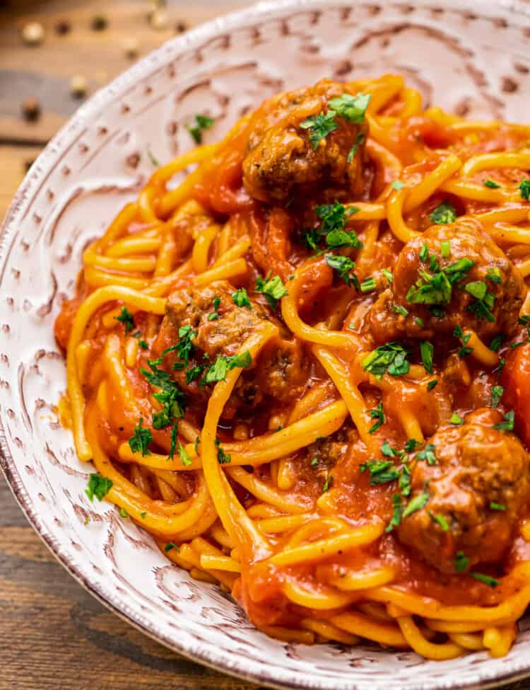 Bowl of spaghetti and meatballs topped with parsely