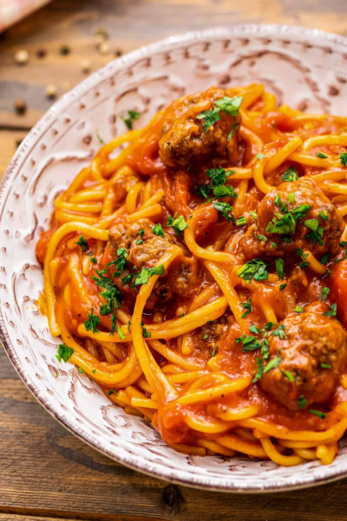 Bowl of spaghetti and meatballs topped with parsely