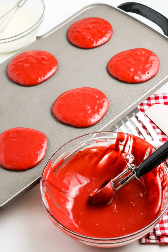 Griddle with red velvet pancakes on it