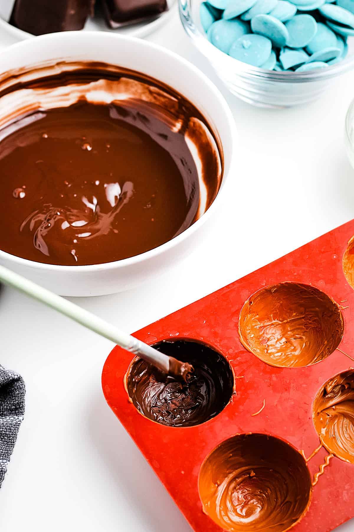 Brushing chocolate into silicone mugs