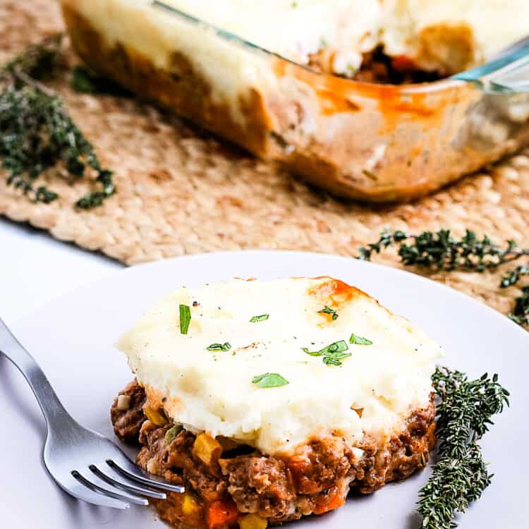 A white plate with a slice of Shepherd's Pie