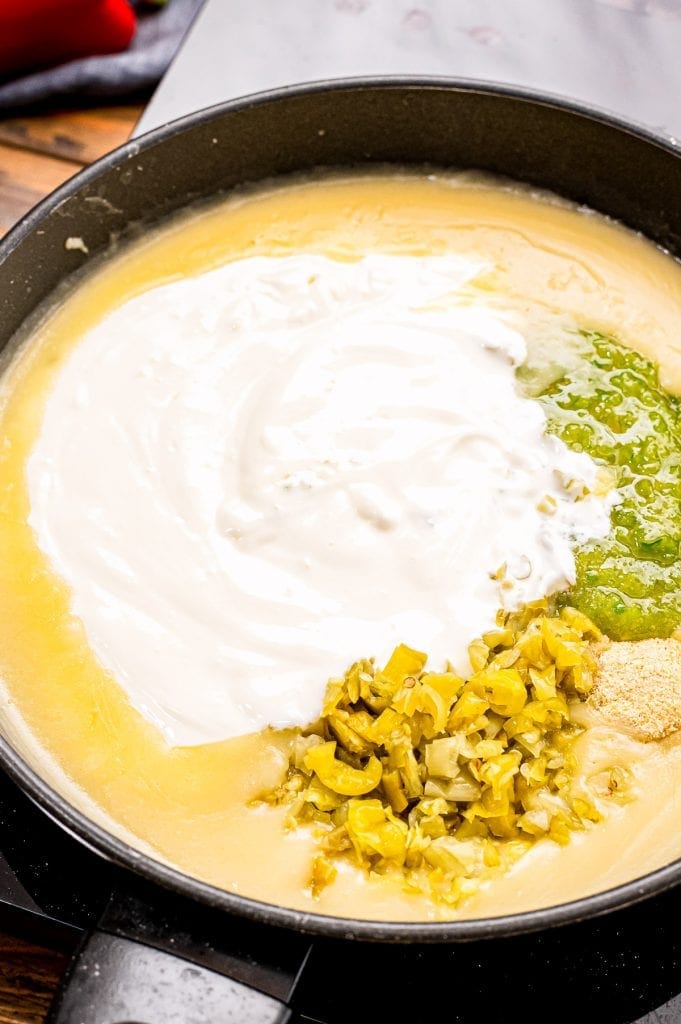 Skillet with the ingredients for a cream sauce for enchiladas before mixing.