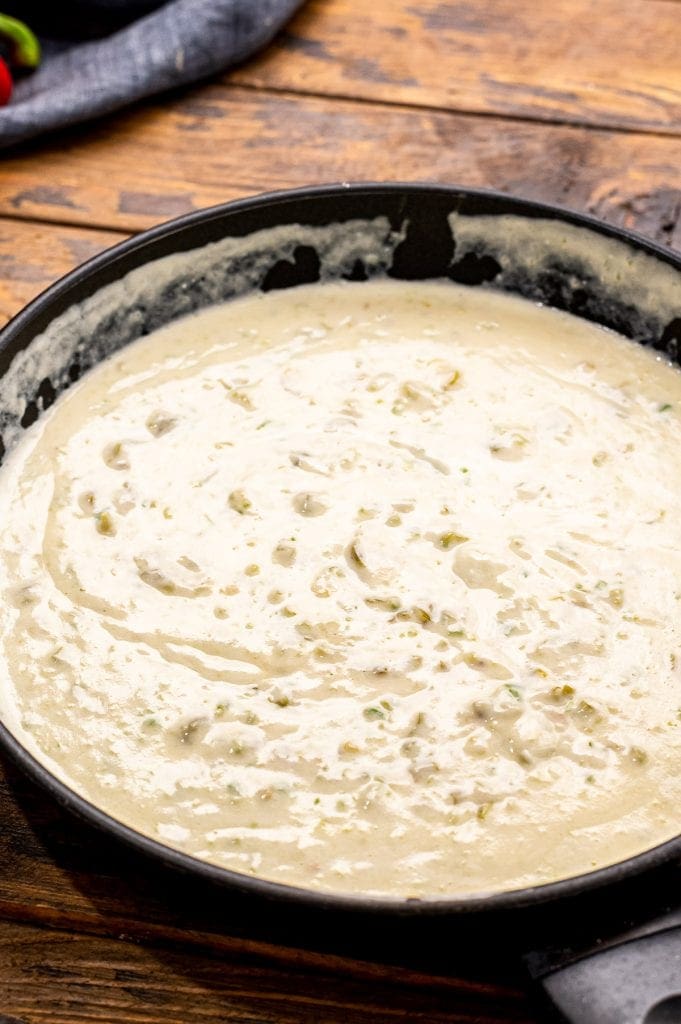 A cream sauce for enchiladas in a skillet after cooking.