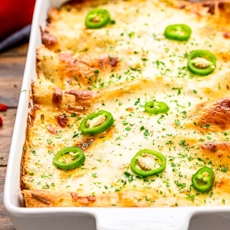 A white casserole dish with shrimp enchiladas in it.