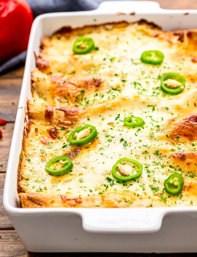 A white casserole dish with shrimp enchiladas in it.