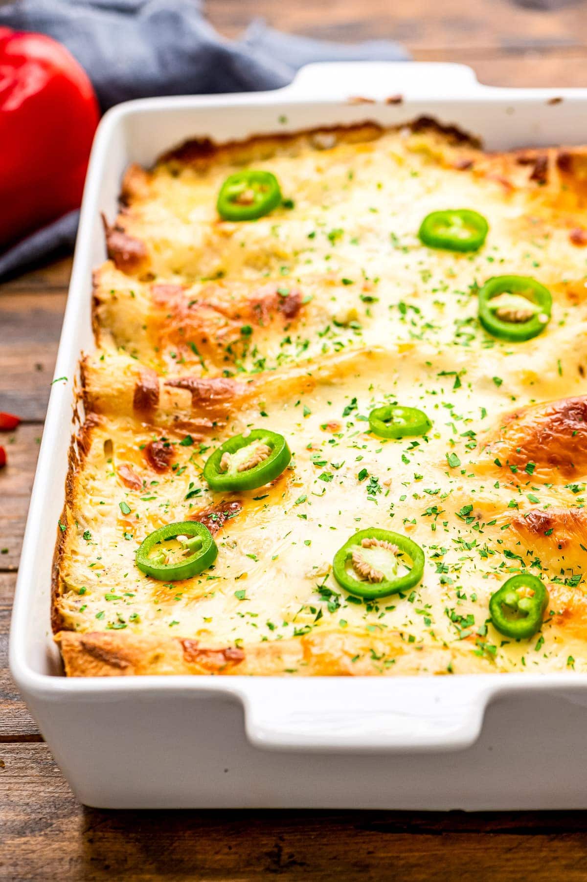 A white casserole dish with shrimp enchiladas in it.