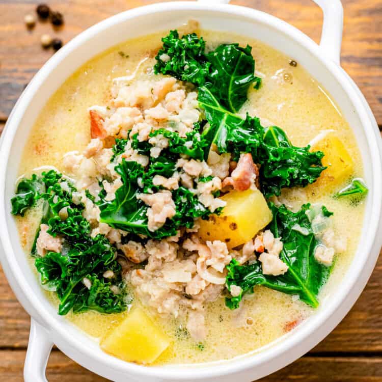 Square close up overhead image of a white bowl of Crock Pot Zuppa Toscana