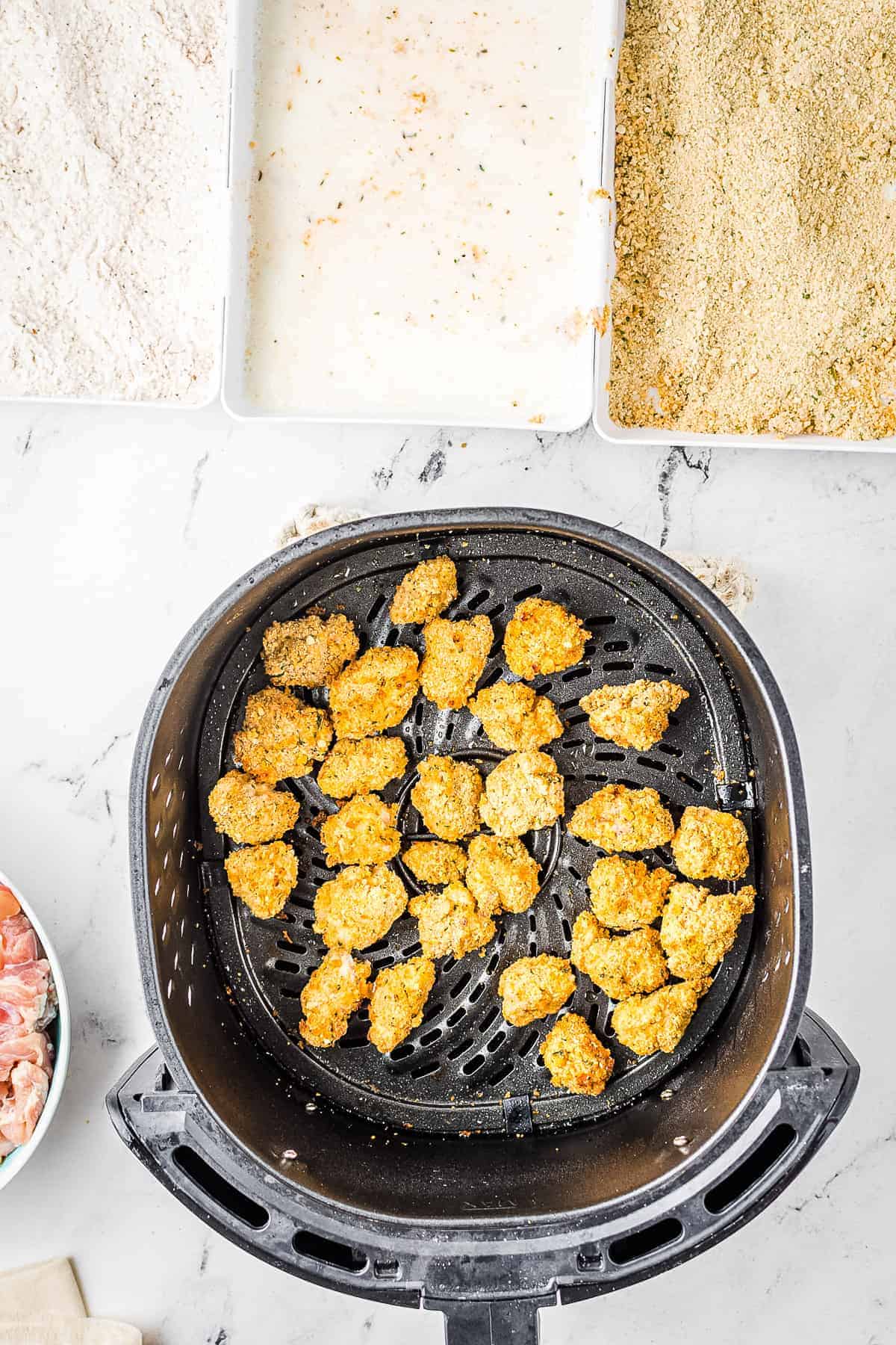 Cooked chicken nuggets in air fryer basket