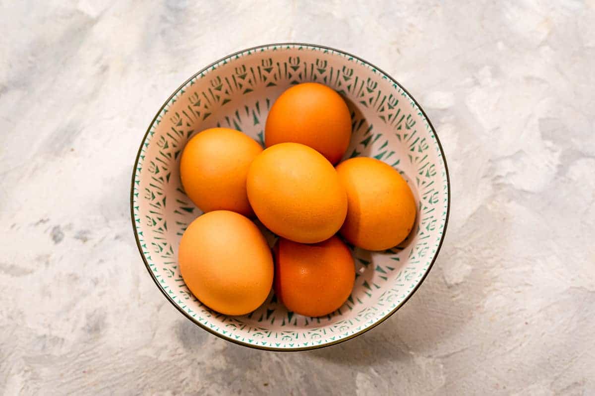 An overhead image of brown eggs in a bowl