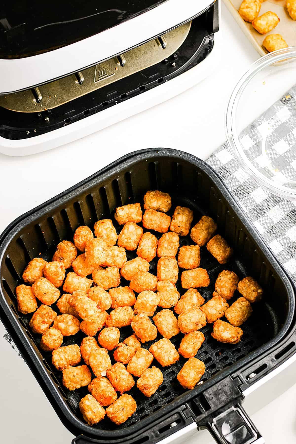 Cooked Tater Tots in air fryer basket